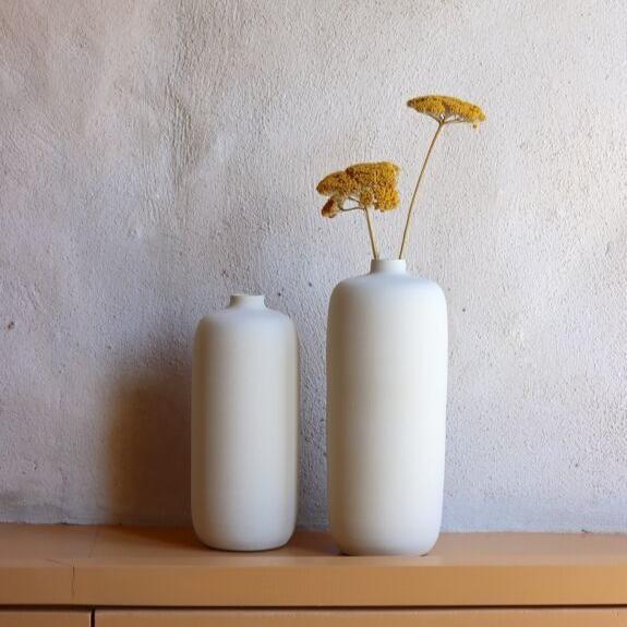 Vases en céramique blanche avec fleurs séchées.