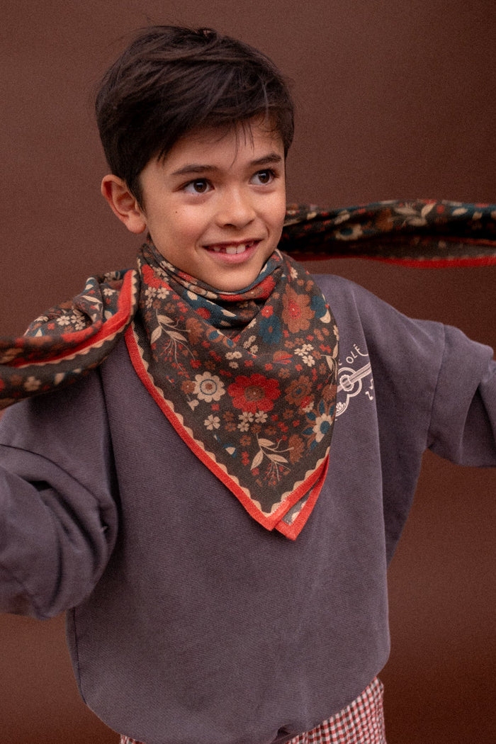 Enfant portant un foulard fleuri en laine Apaches Collections
