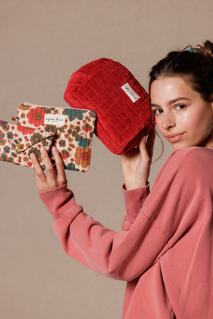 Jeune femme tenant des pochettes fleuries matelassées Apaches Collections, idées cadeaux