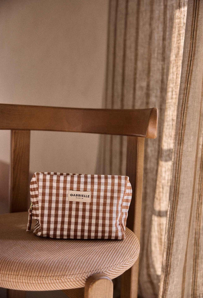 Trousse de toilette vichy Gabrielle Paris posée sur une chaise